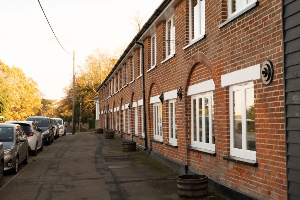 a-row-of-parked-cars-next-to-a-brick-building