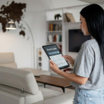 Woman using tablet for home sale in modern living room with world map wall art